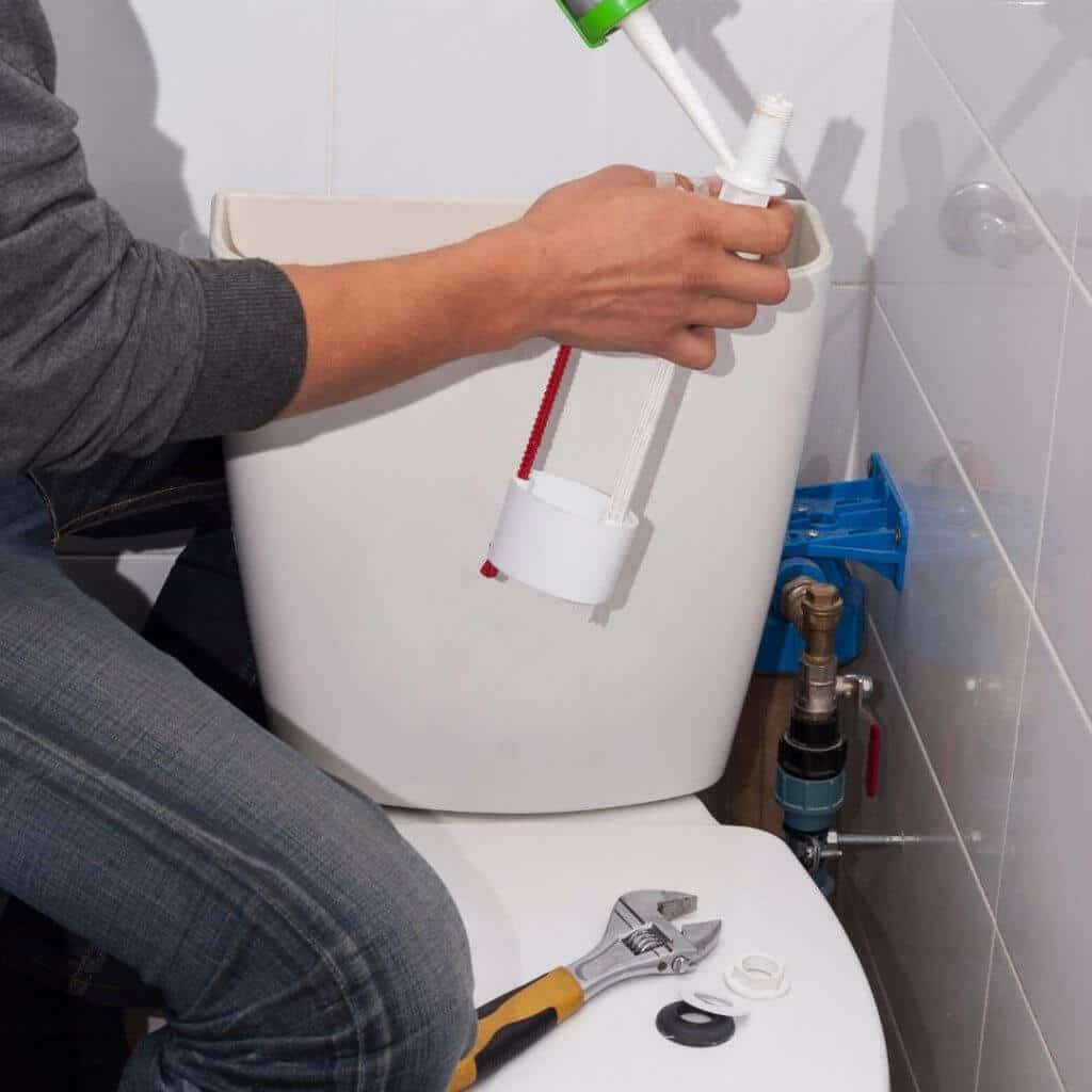men_fixing_toilet_bowl_with_silicone.jpeg